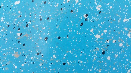 The blue surface has white drops and black drops.