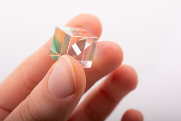 Optical glass cube in hand  Light dispersion,spectrum. Physics optics ray refractions