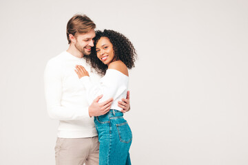 Smiling beautiful woman and her handsome boyfriend. Happy cheerful multiracial family having tender moments on grey background  in studio. Multiethnic models hugging. Embracing each other.Love concept