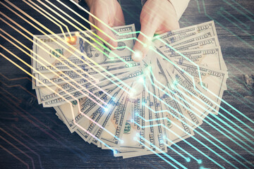 Multi exposure of technology drawing hologram and us dollars bills and man hands. Data concept