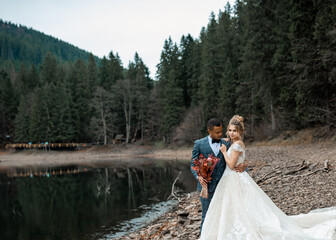 Bride and groom at wedding ceremony on the beautiful lake background.
