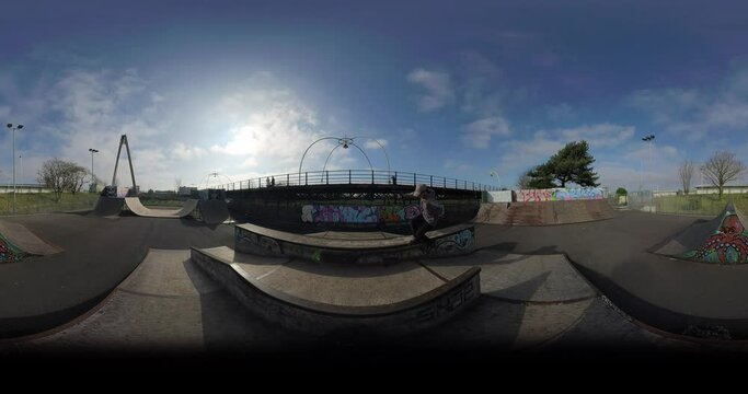 360 VR Skater grinding box and crossing halfpipe on sunny day in empty skatepark