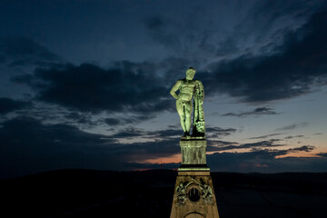 luftaufnahme vom der beleuchteten Spitze des Monumentalbau mit der Figur des Herkules bei Nacht,...