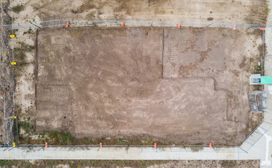 Aerial views on a newly created Australian housing estate. Construction starts on a newly titled block of land, construction fences are up and within months a new house will be built on this site.
