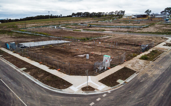 Aerial views on a newly created Australian housing estate. Construction starts on a newly titled block of land, construction fences are up and within months a new house will be built on this site.