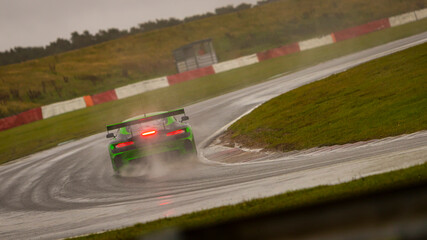 A panning shot of a racing car as it circuits a track.