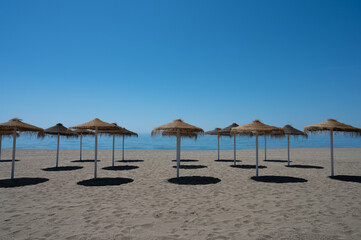 playa con sombrillas vacía de personas con cielo azul
