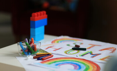 Fototapeta premium A boy of 4-7 years old sits at the table and draws with multi-colored paints. Children's creativity. Children's hobbies. High quality photo