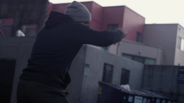 Handsome Latino boxer shadowboxing in the city