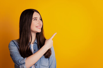 Portrait of positive girl point finger copyspace look side isolated over yellow color background