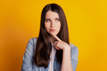 Portrait of cunning woman finger chin look empty space isolated yellow background