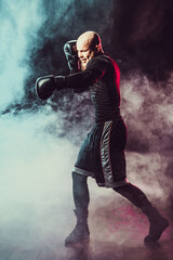 Sportsman boxer fighting on black background with smoke. Boxing