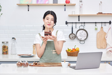 Asia Korean young woman serving a piece of chocolate cake on a plate