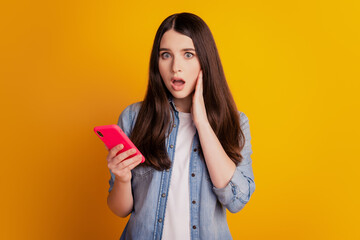 Fototapeta premium Portrait of lovely cheerful girl holding in hands telephone crazy reaction look screen