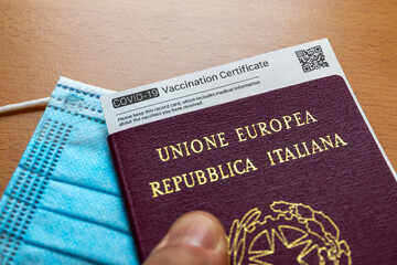 Italian passport with vaccination certificate. COVID-19 Vaccination Record card whith QR Code, Passport of Italy and Medical Mask. Immune passport or certificate for travel concept.