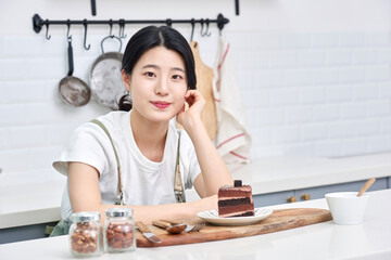 Fototapeta na wymiar Asia Korean young woman serving a piece of chocolate cake on a plate