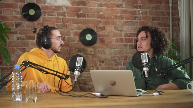 Man influencers recording live podcast audio interview on microphone in home studio Spbd. Two guys