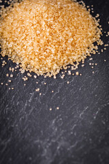 cane brown sugar on a dark stone background