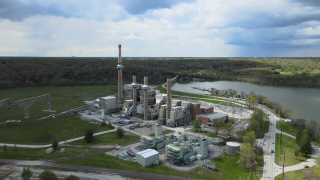Aerial birds eye view shot of a big industrial factory near the riverside. High quality 4k footage