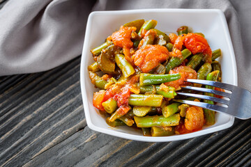 stewed green beans on a dark wooden rustic background