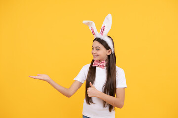 cheerful kid presenting product. happy easter holiday. funny child in rabbit ears. teenager girl