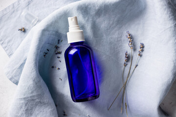 lavender spray in transparent glass bottle on linen sheet. Insomnia or depression treatment for...