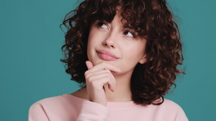 The portrait of a pensive woman thinking about something in a blue studio - Powered by Adobe