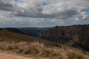 Steep Rocky Cliffs Leading Down into a Tree Lined Gorge