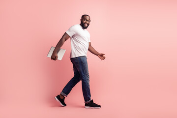 Fototapeta na wymiar Young smiling african man walk carry laptop