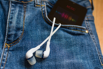 Jeans With A Smartphone And Headphones In The Pocket Of The Pants.