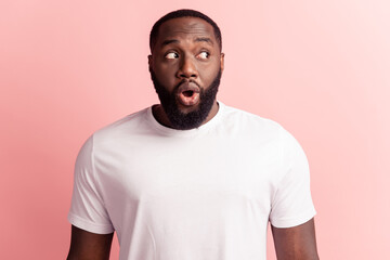 Young handsome curious funky man with beard excited face on pink background