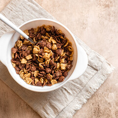 Tasty and healthy breakfast. Chocolate and vanilla cornflakes with milk in a white bowl top view. Breakfast cereals.