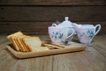 Crackers in wooden trays and tea sets on old wood floors and walls
