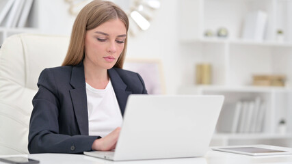 Focused Businesswoman Working on Laptop in Office 