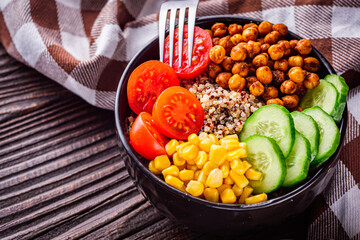 bowl of healthy quinoa with vegetables on a dark rustic background