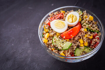 bowl of healthy quinoa with vegetables on a dark rustic background
