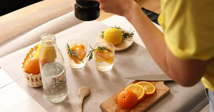 Woman food photographer take pictures with camera of fresh summer citrus lemonade drink on white background, Concept of food photo blogging.