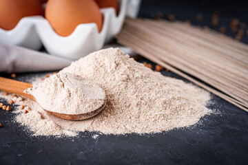 fresh natural buckwheat flour on a dark stone background culinary concept