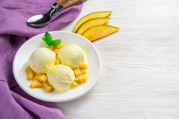 Mango ice cream on a white background with a purple napkin.