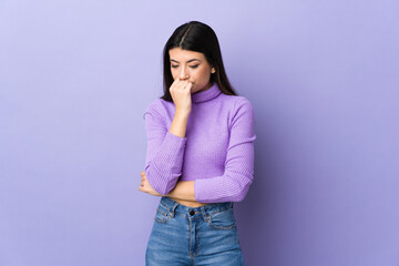 Young brunette woman over isolated purple background having doubts