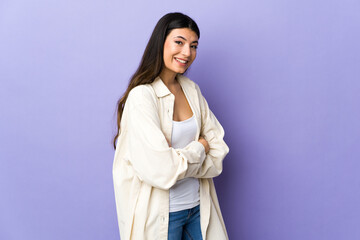 Fototapeta premium Young brunette woman over isolated purple background looking to the side and smiling