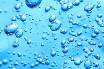Close up macro Aloe vera gel cosmetic texture blue background with bubbles. Lemongrass gel skincare product. antibacterial liquid with aloe vera, moisturizing. Safe and environmental friendly.