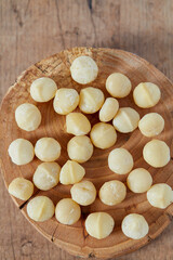 macadamian nuts on dark wooden surface