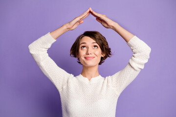 Photo portrait of pretty brunette keeping roof with hands over head isolated on pastel purple color...