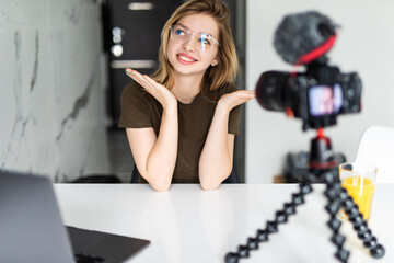 Fototapeta na wymiar Modern influencer. Female vlogger making social media video while sitting indoors