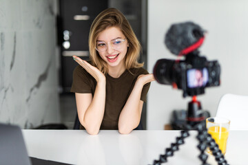Naklejka na ściany i meble Modern influencer. Female vlogger making social media video while sitting indoors