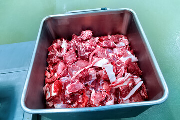 Large pieces of meat in the steel tank at the meat factory.