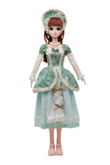 Detail shot of collector's hinged doll in lace bonnet, shoes, green dress with floral design, lace trimming and bow brooch. Brown-haired doll in necklace and earrings is located on white background. 