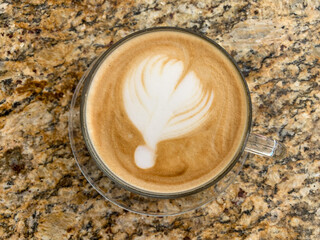 Top view of latte cup on a stone table background. Coffee cup with beautiful latte art.