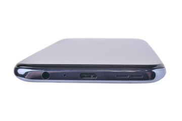 The end part of the smartphone on which there is a charging socket, a microphone, a headphone input and speakers. On a white background, close-up